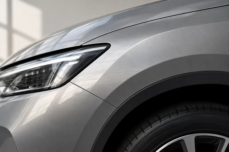 Illustrative close-up of a silver vehicle’s fender and headlight